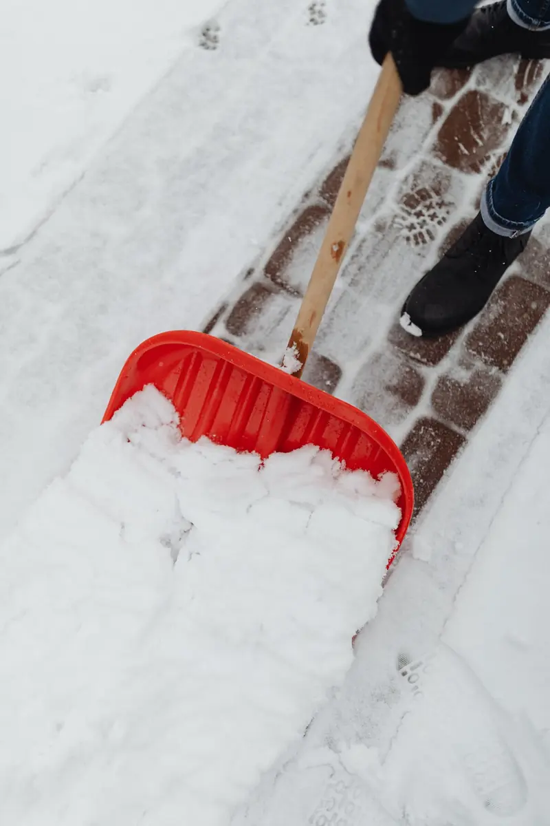Winterdienst: Schneeschaufel räumt einen Gehweg