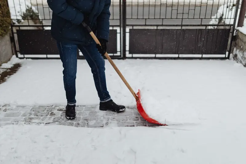 Winterdienst: Schneeschaufel räumt einen Gehweg