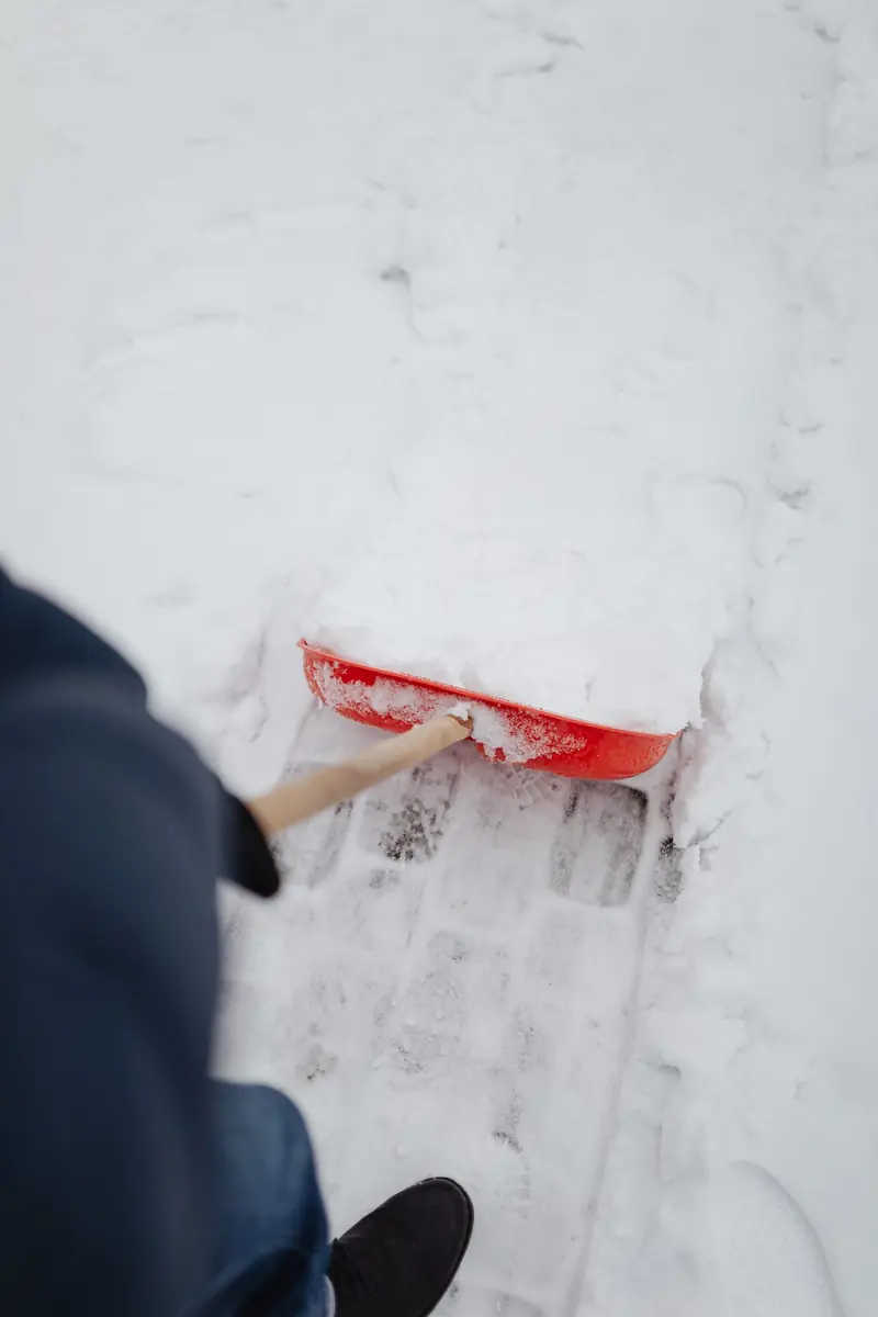 Winterdienst: Schneeschaufel räumt einen Gehweg